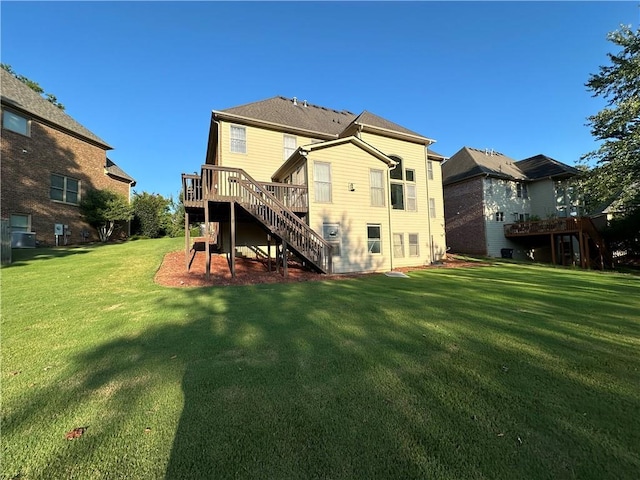 rear view of property featuring stairway, a lawn, and a wooden deck