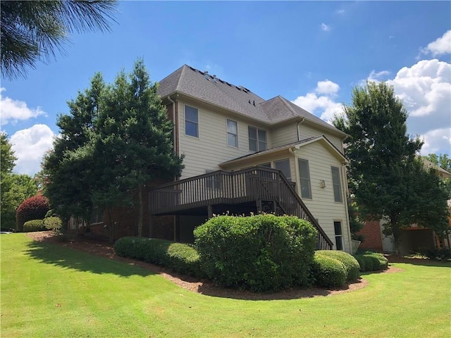 rear view of property with a deck, stairway, and a yard