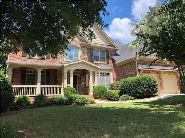 view of front of house featuring a front lawn, a porch, brick siding, and stone siding