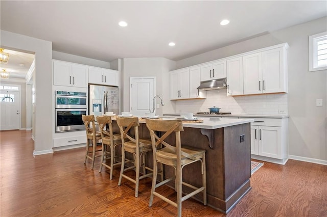 kitchen featuring white cabinetry, appliances with stainless steel finishes, sink, and an island with sink