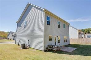 back of house with cooling unit, a yard, and a patio