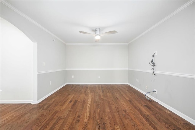 empty room featuring dark wood-type flooring, ceiling fan, and crown molding