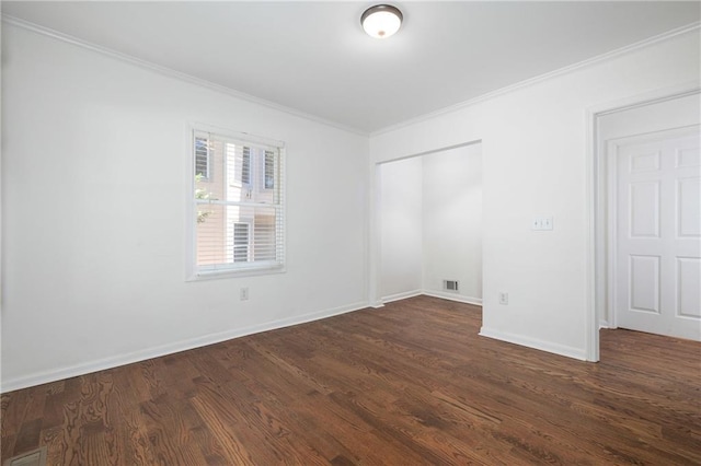 spare room featuring ornamental molding and dark hardwood / wood-style floors