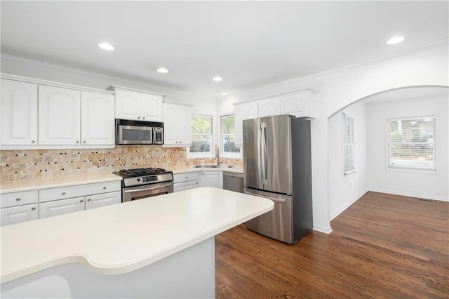 kitchen featuring white cabinetry, decorative backsplash, a healthy amount of sunlight, and appliances with stainless steel finishes