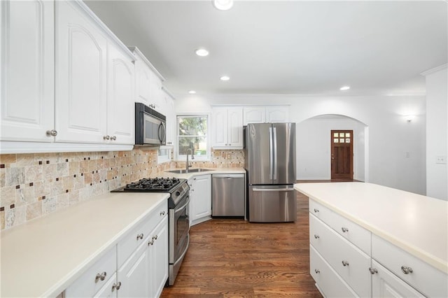 kitchen with sink, stainless steel appliances, tasteful backsplash, white cabinets, and dark hardwood / wood-style flooring