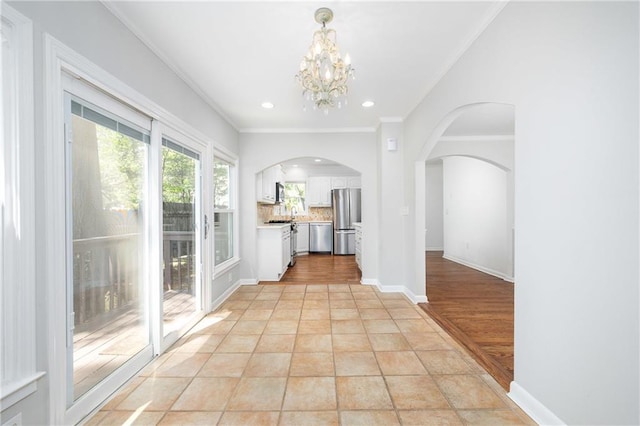 interior space featuring crown molding, light tile patterned floors, and a chandelier