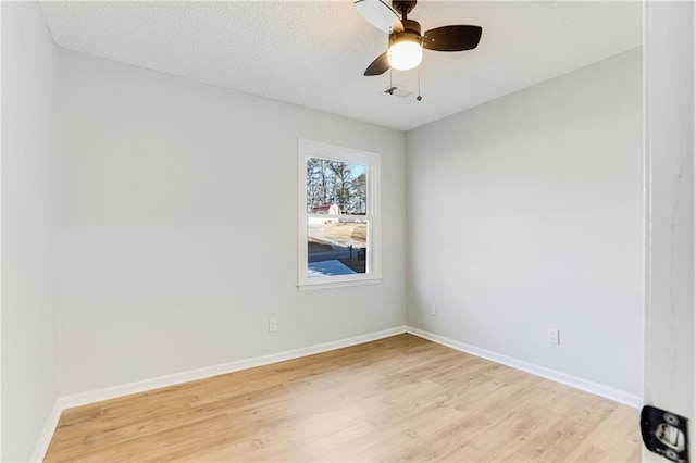 spare room with ceiling fan, light hardwood / wood-style floors, and a textured ceiling