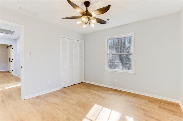 unfurnished bedroom with ceiling fan, light hardwood / wood-style floors, and a closet