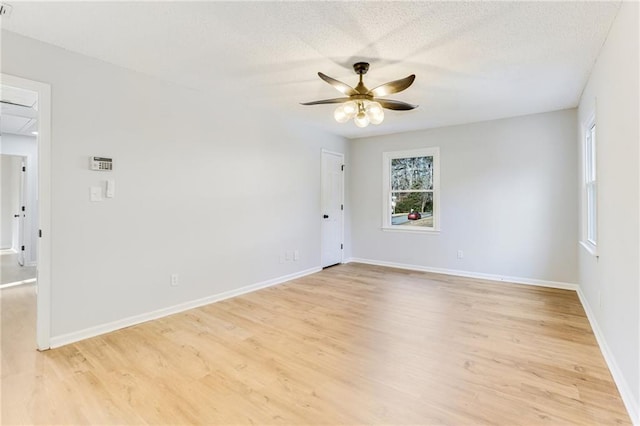 spare room with ceiling fan, light hardwood / wood-style floors, and a textured ceiling