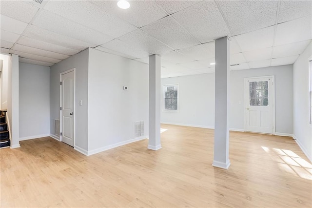 basement with a drop ceiling and light wood-type flooring