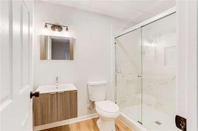 bathroom featuring toilet, hardwood / wood-style floors, vanity, and walk in shower