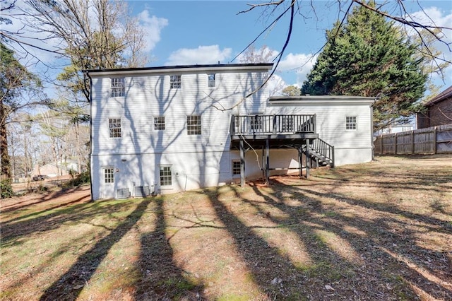 back of property featuring a wooden deck and a yard