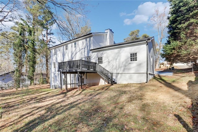 back of house with a wooden deck and a lawn