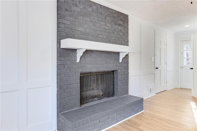 interior details with hardwood / wood-style floors, a fireplace, and a textured ceiling