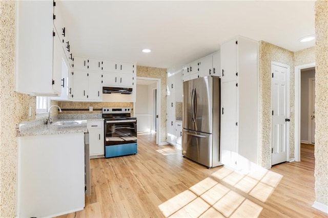 kitchen featuring stainless steel appliances, white cabinetry, sink, and light hardwood / wood-style floors