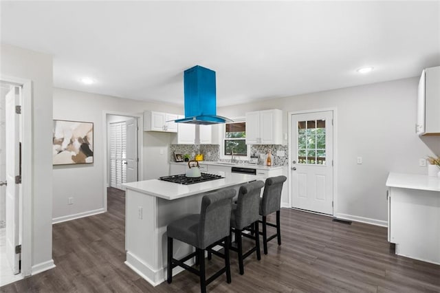 389 Oglesby Bridge Rd SE, Conyers, GA 30094 - kitchen with island range hood, black gas cooktop, white cabinetry, dark wood finished floors, and light countertops