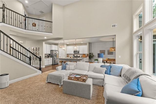 carpeted living room featuring a high ceiling