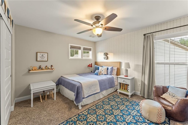 carpeted bedroom featuring ceiling fan and a closet