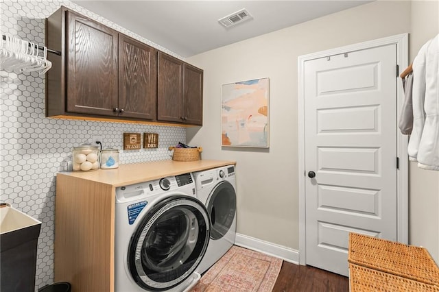 clothes washing area featuring cabinets, dark hardwood / wood-style flooring, and independent washer and dryer