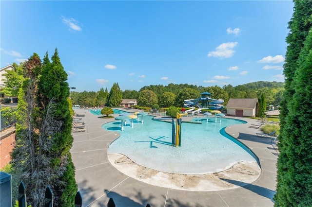 view of swimming pool with a patio and a water slide