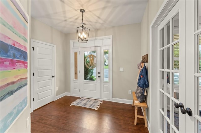 foyer with an inviting chandelier, dark wood-type flooring, and a healthy amount of sunlight