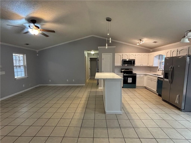 kitchen with light tile patterned floors, appliances with stainless steel finishes, white cabinetry, hanging light fixtures, and ornamental molding