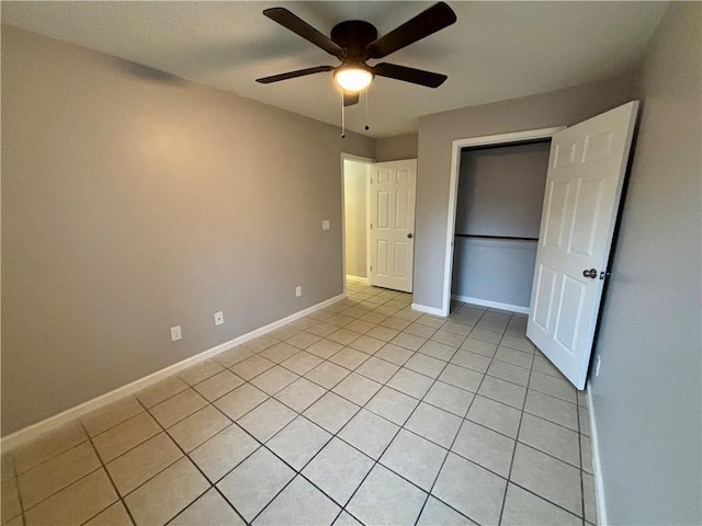 unfurnished bedroom with light tile patterned floors, a closet, and ceiling fan