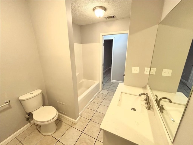 bathroom with tile patterned flooring, vanity, a textured ceiling, and toilet