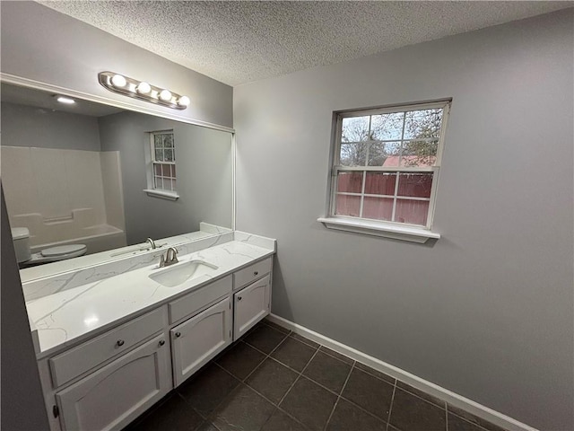 bathroom featuring vanity, tile patterned floors, a textured ceiling, and toilet