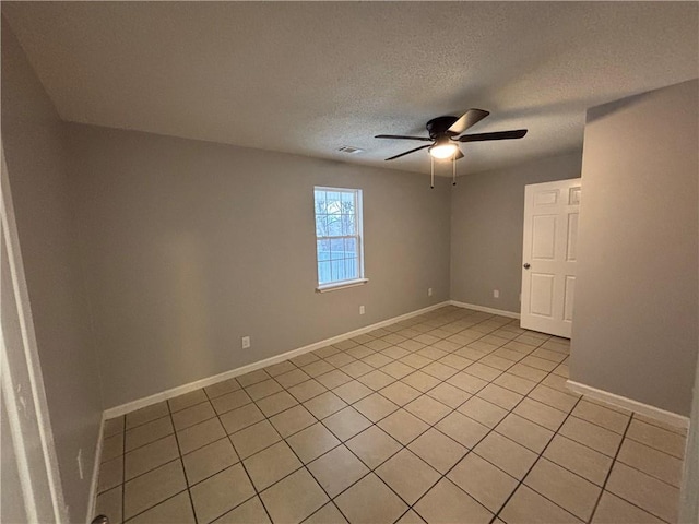 tiled empty room featuring a textured ceiling and ceiling fan