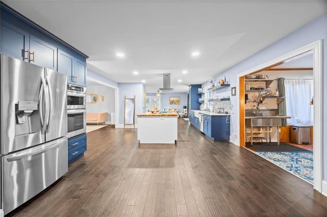 200 Mcguirts Bridge Rd, Covington, GA 30014 - kitchen featuring stainless steel appliances, blue cabinetry, dark wood finished floors, and recessed lighting