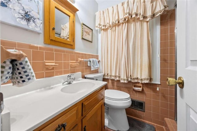 200 Mcguirts Bridge Rd, Covington, GA 30014 - bathroom with tile walls, toilet, double vanity, and a wainscoted wall