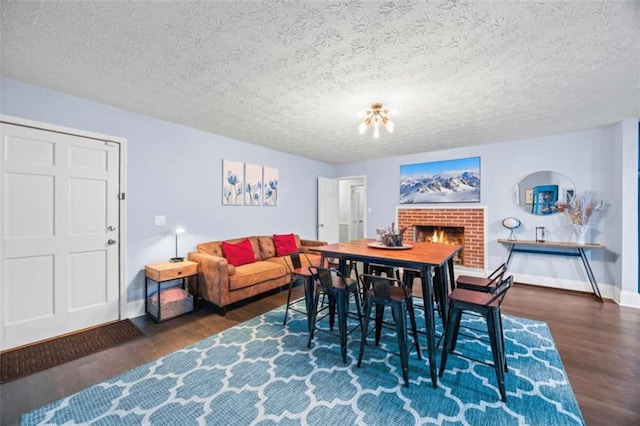200 Mcguirts Bridge Rd, Covington, GA 30014 - dining space featuring wood finished floors, baseboards, a textured ceiling, and a fireplace
