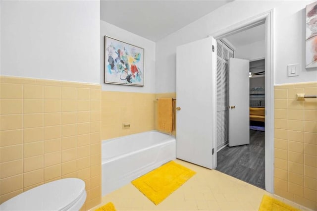 200 Mcguirts Bridge Rd, Covington, GA 30014 - full bath with tile walls, a bath, toilet, and wainscoting