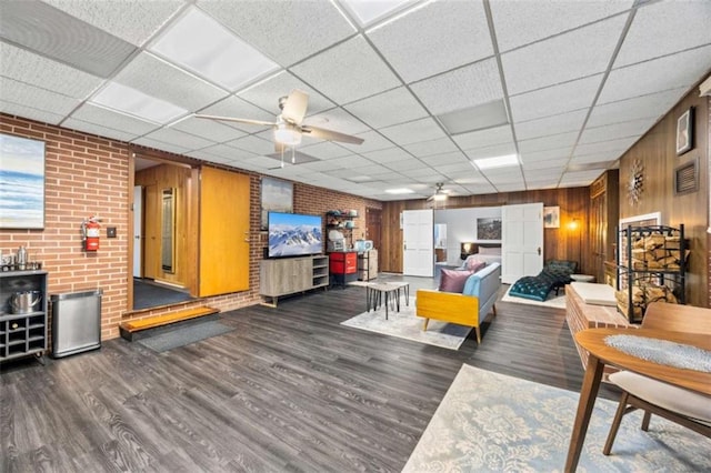 200 Mcguirts Bridge Rd, Covington, GA 30014 - living room featuring a ceiling fan, a drop ceiling, wood finished floors, and wood walls