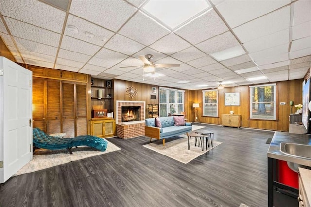 200 Mcguirts Bridge Rd, Covington, GA 30014 - living area featuring wooden walls, wood finished floors, ceiling fan, plenty of natural light, and a drop ceiling