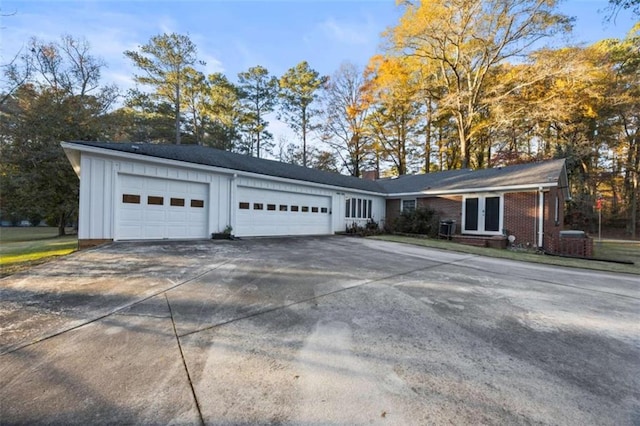 200 Mcguirts Bridge Rd, Covington, GA 30014 - view of front facade with french doors, board and batten siding, driveway, an attached garage, and a chimney