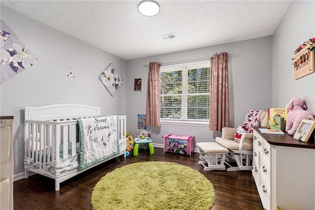 6492 Swift Creek Rd, Lithonia, GA 30058 - bedroom featuring dark wood finished floors, a textured ceiling, and a crib