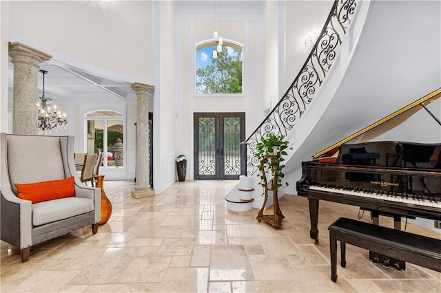 entrance foyer featuring ornate columns, french doors, a chandelier, and a high ceiling