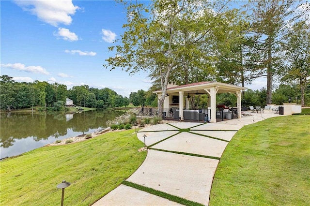 view of property's community with a gazebo, a lawn, and a water view