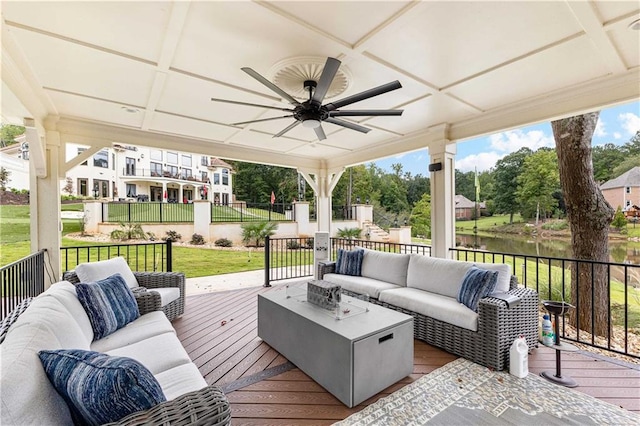 wooden terrace featuring a water view, outdoor lounge area, a lawn, and ceiling fan