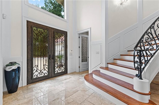 foyer featuring a towering ceiling and french doors