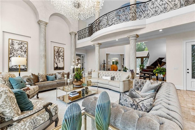 living room with an inviting chandelier, decorative columns, and a high ceiling