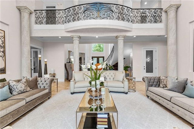 living room with decorative columns and a high ceiling