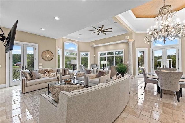 living room featuring french doors, ceiling fan with notable chandelier, crown molding, and ornate columns