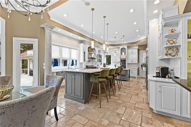 kitchen with plenty of natural light, hanging light fixtures, a large island, and white cabinetry