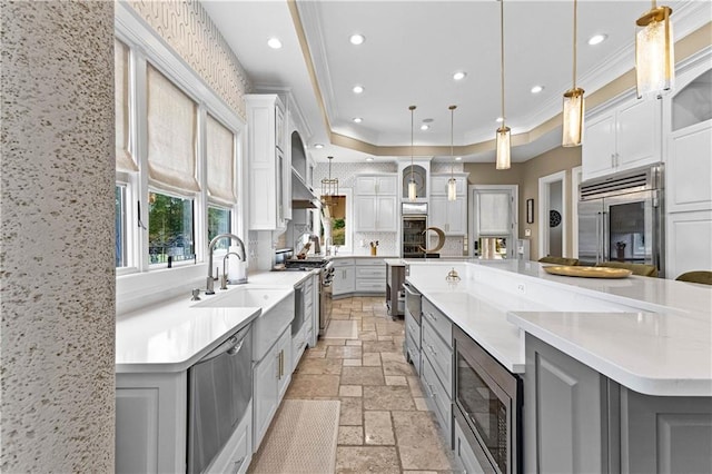 kitchen with white cabinets, built in appliances, a large island, gray cabinets, and decorative light fixtures