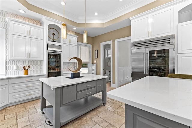 kitchen with gray cabinets, decorative light fixtures, stainless steel built in fridge, white cabinets, and a center island