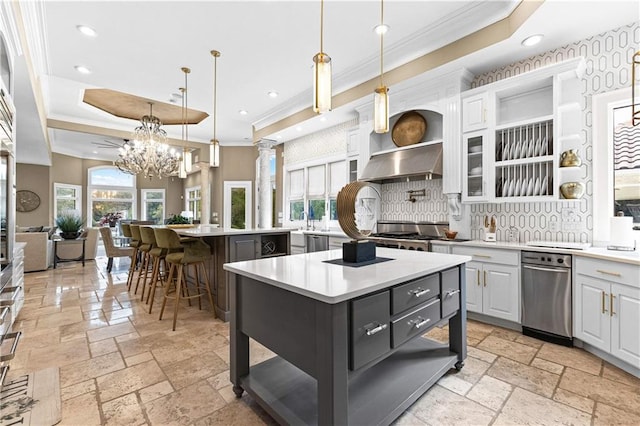 kitchen featuring a kitchen island, decorative light fixtures, white cabinetry, and a kitchen breakfast bar