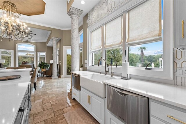 kitchen featuring ornate columns, sink, dishwasher, ornamental molding, and white cabinetry